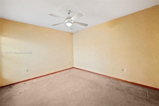 carpeted spare room with ceiling fan, baseboards, and a textured ceiling