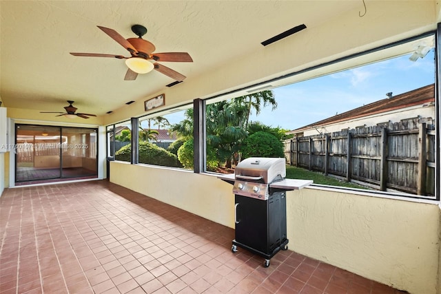 unfurnished sunroom with a ceiling fan