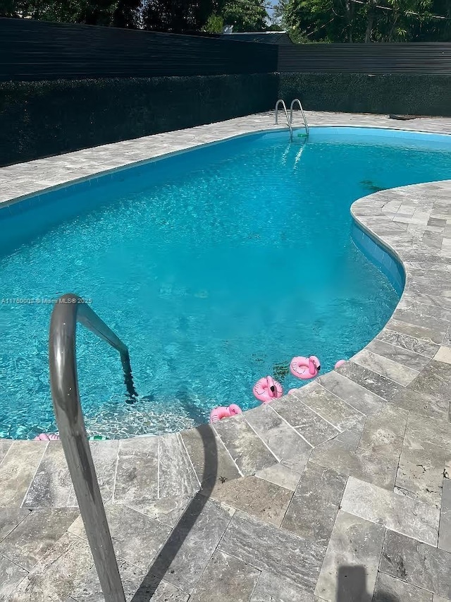 view of swimming pool featuring a fenced in pool and fence