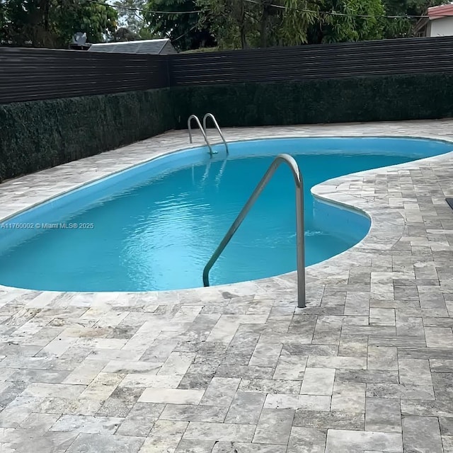 view of swimming pool with a fenced in pool, a patio, and fence