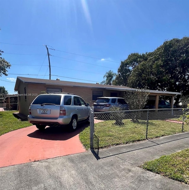 view of front facade with a fenced front yard, an attached garage, concrete driveway, and a front lawn