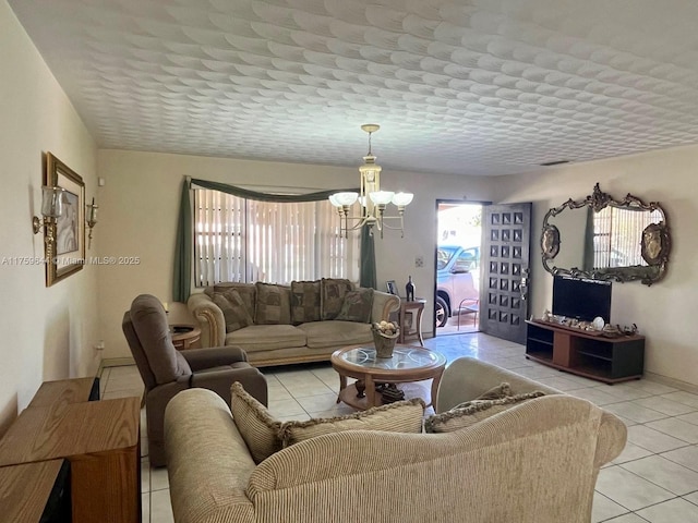 living room featuring light tile patterned floors, a textured ceiling, and an inviting chandelier