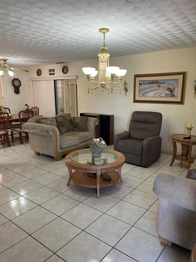 living room with light tile patterned flooring, ceiling fan with notable chandelier, and a textured ceiling