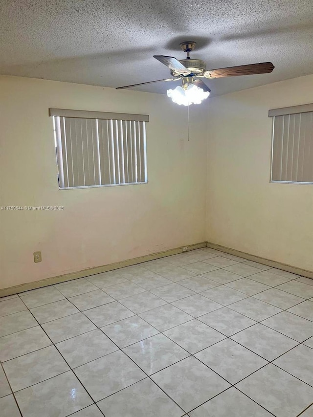 unfurnished room with a textured ceiling, baseboards, and a ceiling fan