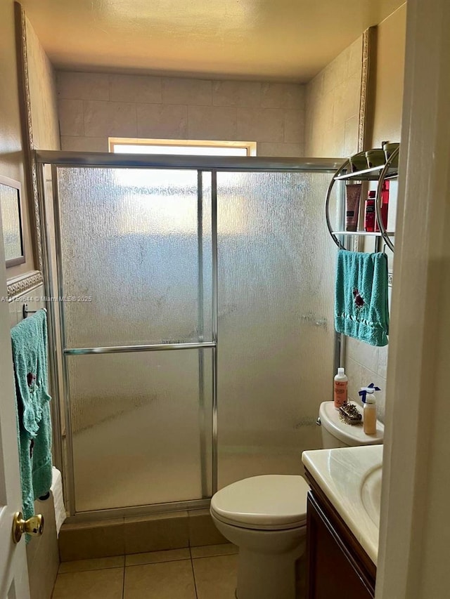 full bathroom featuring tile patterned flooring, a shower stall, vanity, and toilet