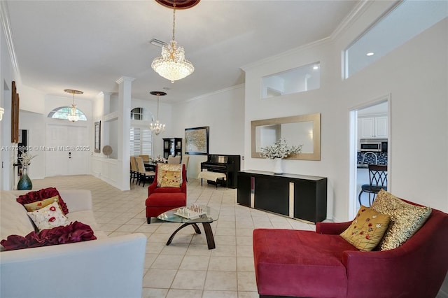 living area with visible vents, ornate columns, light tile patterned flooring, ornamental molding, and a chandelier