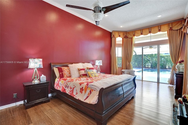 bedroom with baseboards, ornamental molding, wood finished floors, a textured ceiling, and access to outside