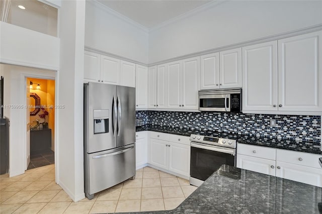 kitchen featuring ornamental molding, light tile patterned floors, decorative backsplash, appliances with stainless steel finishes, and white cabinets