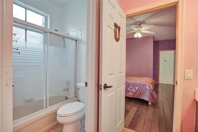 full bathroom featuring toilet, a ceiling fan, ensuite bath, wood finished floors, and combined bath / shower with glass door