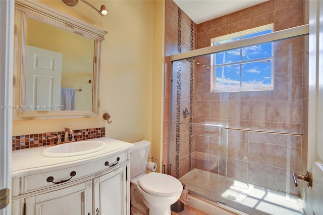 full bathroom featuring decorative backsplash, a shower stall, toilet, and vanity