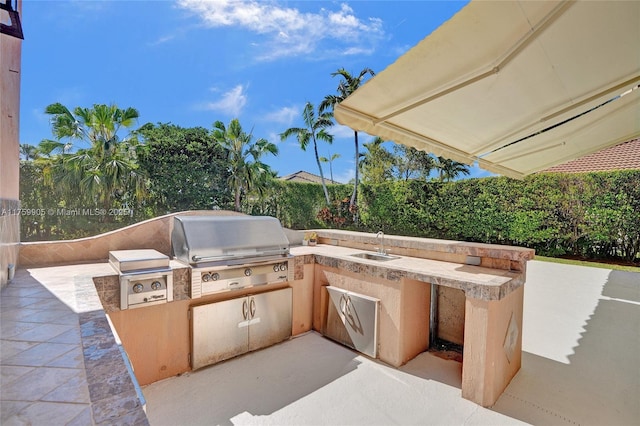 view of patio / terrace with exterior kitchen, area for grilling, and a sink