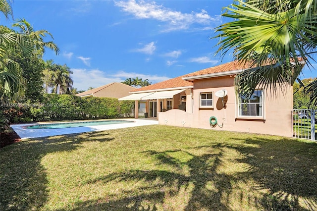 back of house with a fenced in pool, fence, stucco siding, a yard, and a patio