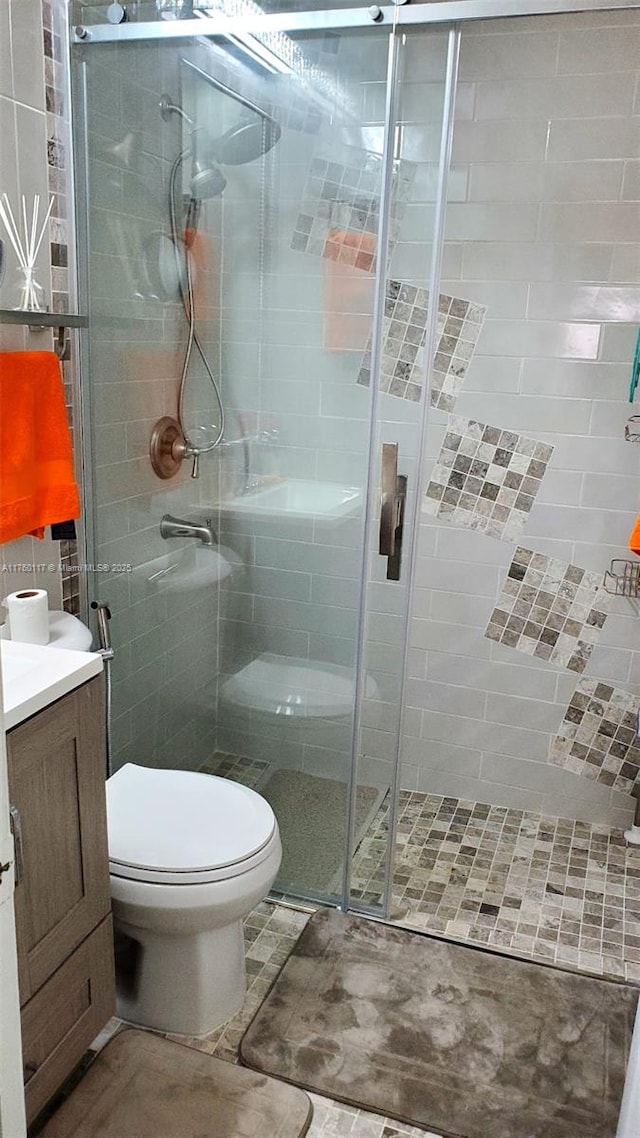 full bath with a shower stall, toilet, and vanity