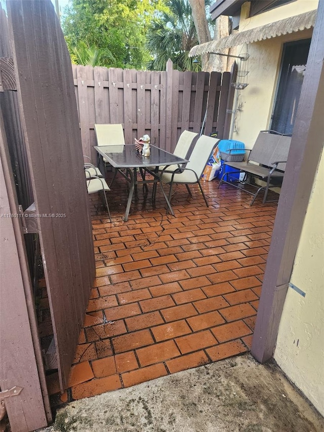 view of patio with outdoor dining space and fence