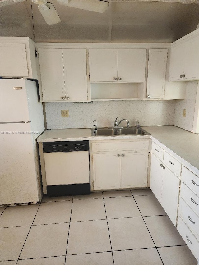 kitchen featuring light tile patterned floors, white cabinets, white appliances, and a sink