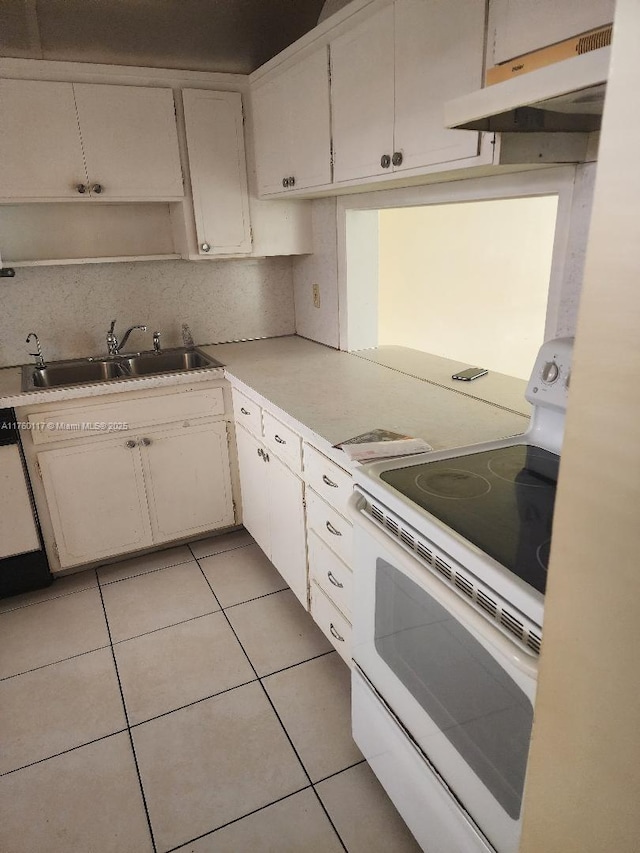 kitchen featuring under cabinet range hood, a sink, white range with electric stovetop, light tile patterned floors, and decorative backsplash