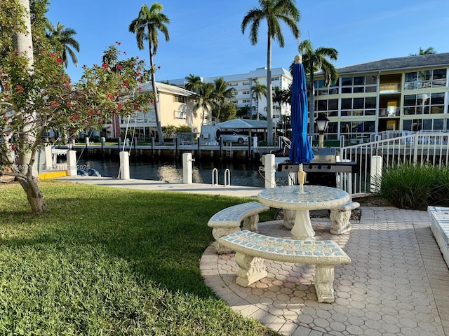 surrounding community with a lawn, a water view, and a boat dock