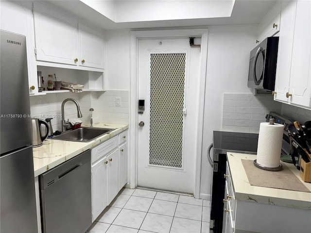 kitchen featuring light countertops, tasteful backsplash, stainless steel appliances, a sink, and white cabinets