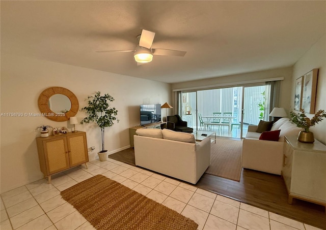 living area with light tile patterned floors and ceiling fan