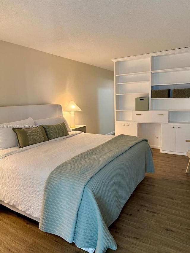 bedroom with a textured ceiling and wood finished floors