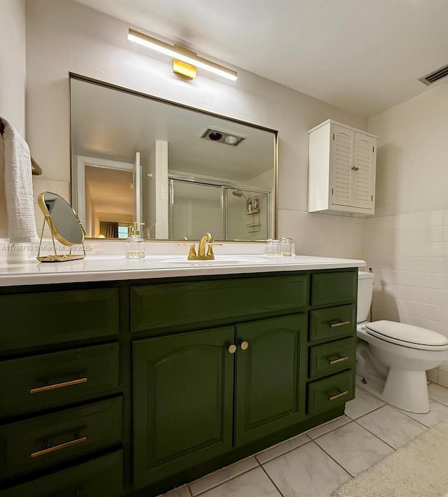 full bath featuring vanity, visible vents, a stall shower, tile walls, and toilet