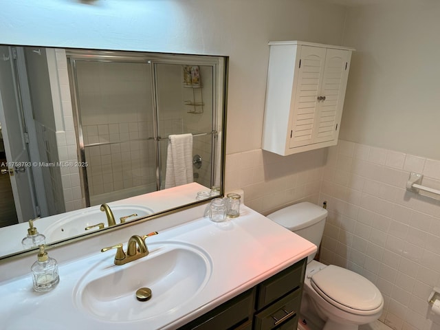bathroom featuring tiled shower, toilet, vanity, and tile walls