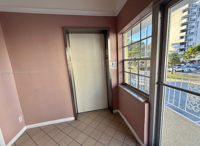 doorway featuring light tile patterned floors, baseboards, elevator, and crown molding