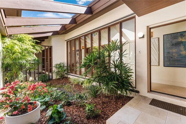 5780 Magnolia Ln, Coral Gables, FL 33156 - property entrance with stucco siding and a pergola