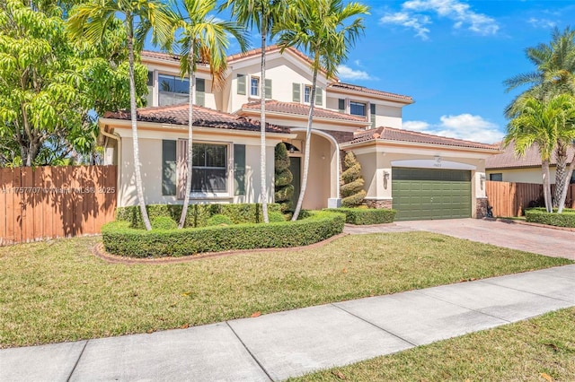 mediterranean / spanish home with a front yard, fence, driveway, and stucco siding