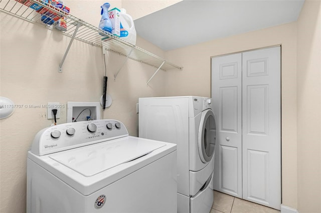 laundry room featuring light tile patterned flooring, laundry area, and washing machine and dryer