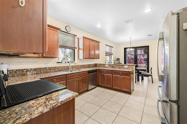 kitchen featuring visible vents, a sink, stainless steel appliances, a peninsula, and light tile patterned floors