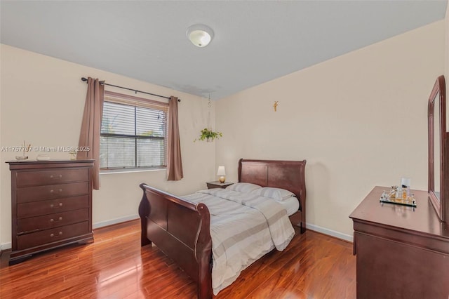 bedroom with baseboards and wood finished floors