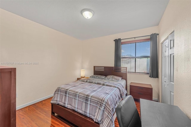 bedroom featuring baseboards and wood finished floors