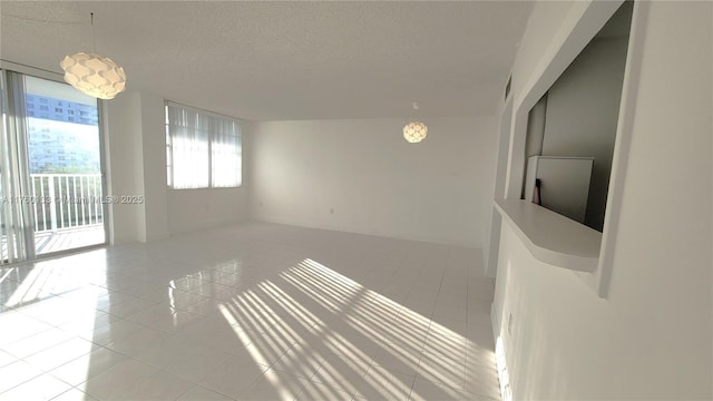 unfurnished room with light tile patterned floors and a textured ceiling