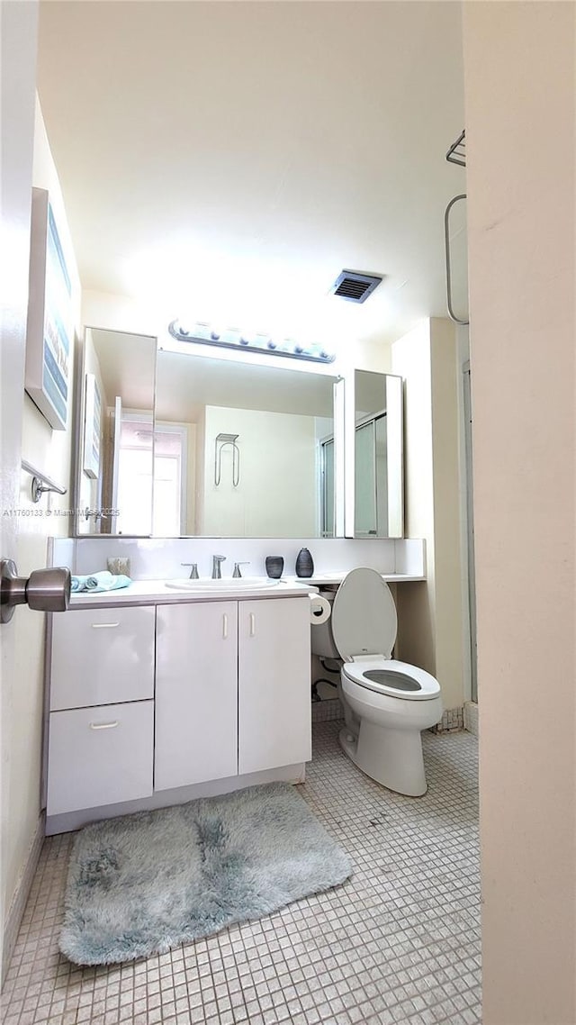 full bath with vanity, toilet, visible vents, and tile patterned flooring