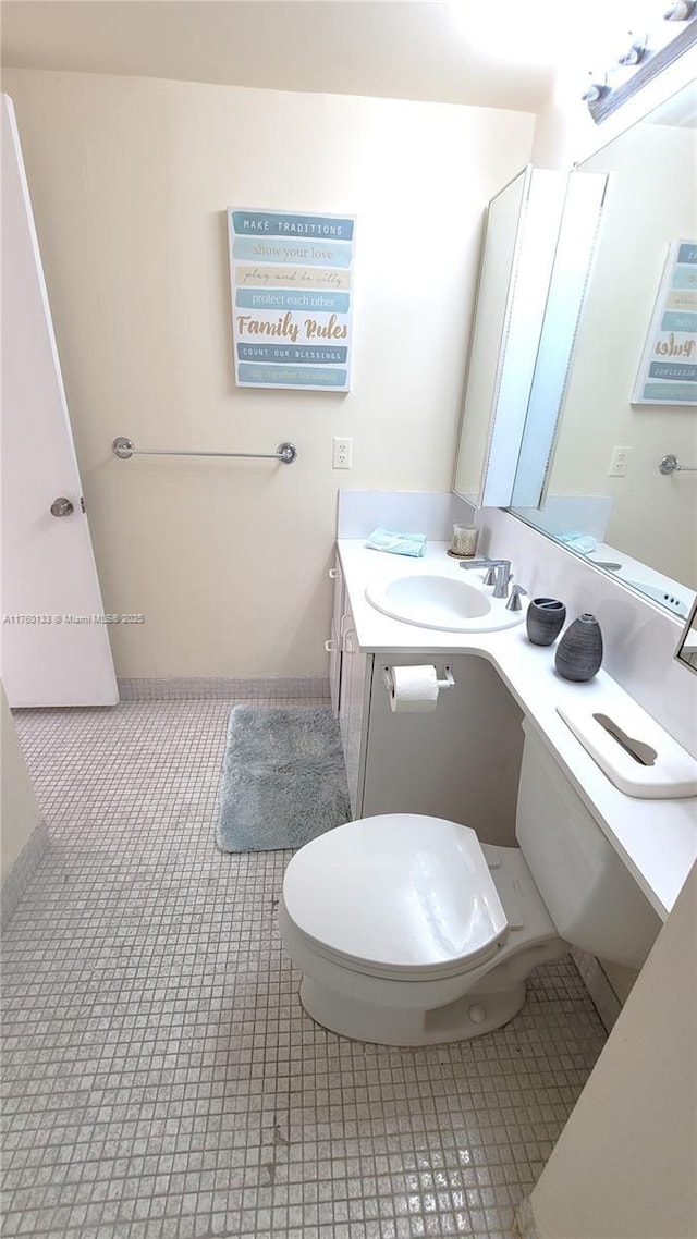 bathroom featuring tile patterned floors, toilet, and vanity