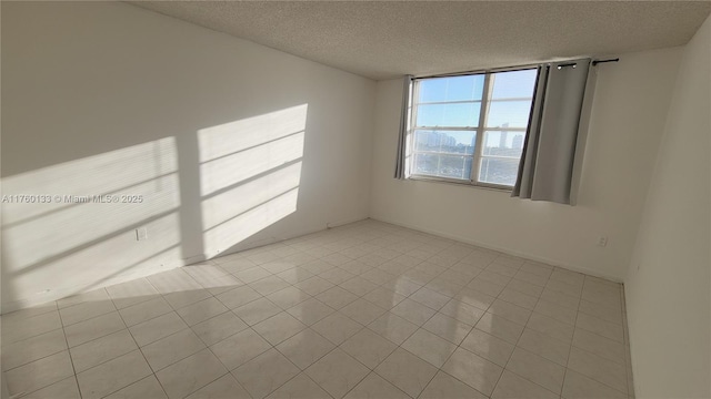 unfurnished room with tile patterned floors and a textured ceiling