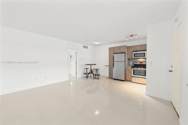 kitchen with visible vents, decorative backsplash, appliances with stainless steel finishes, modern cabinets, and brown cabinets