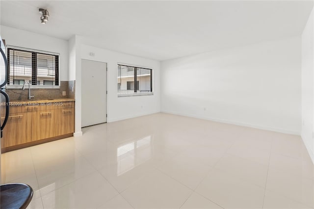 interior space featuring tasteful backsplash, plenty of natural light, modern cabinets, and a sink