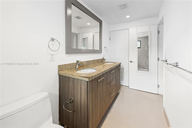 bathroom with toilet, visible vents, and a sink