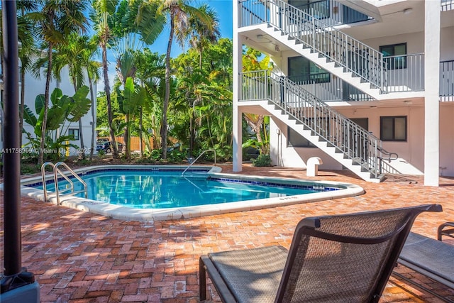 community pool with stairs and a patio area