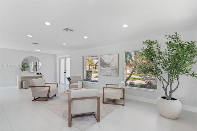 living area with recessed lighting, visible vents, and a healthy amount of sunlight