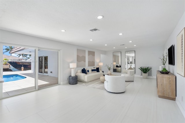 living room featuring recessed lighting, visible vents, and baseboards