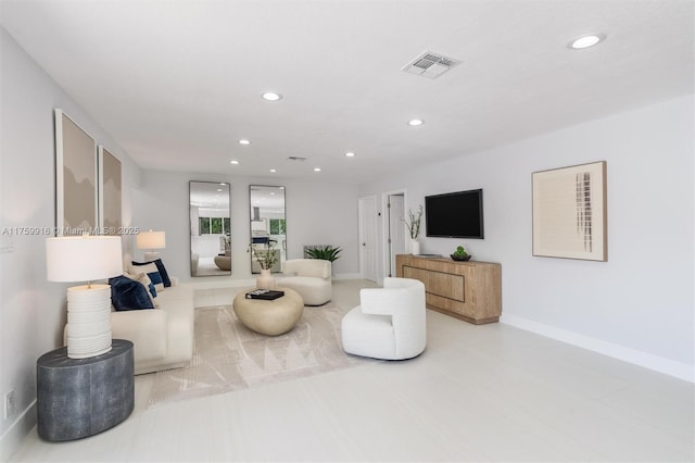 living area with recessed lighting, visible vents, and baseboards