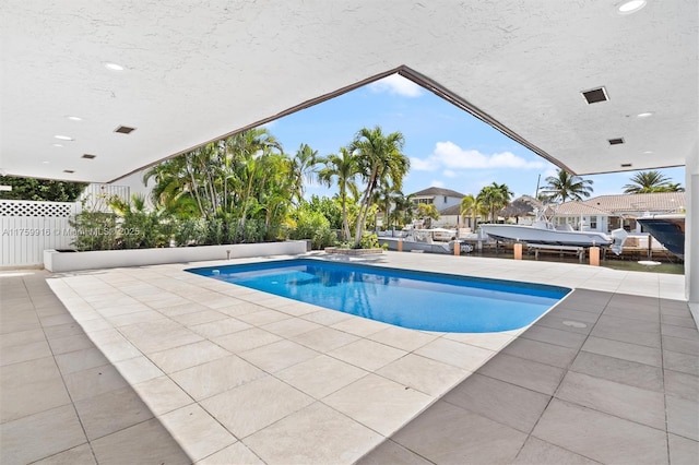 pool with a patio and fence