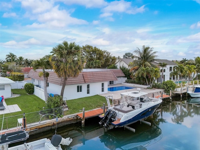 dock area with a fenced in pool, a yard, a fenced backyard, and a water view