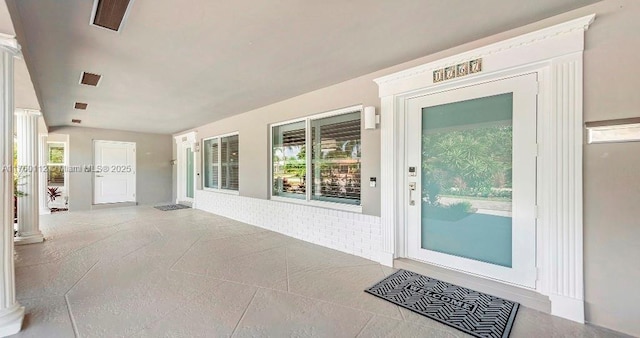 view of exterior entry with brick siding and stucco siding