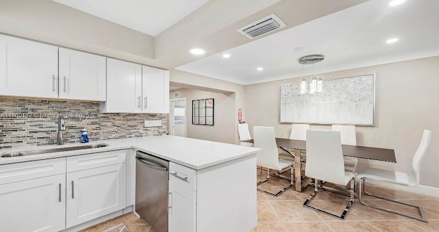 kitchen with tasteful backsplash, visible vents, a sink, a peninsula, and stainless steel dishwasher