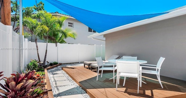 wooden terrace featuring outdoor dining area and fence