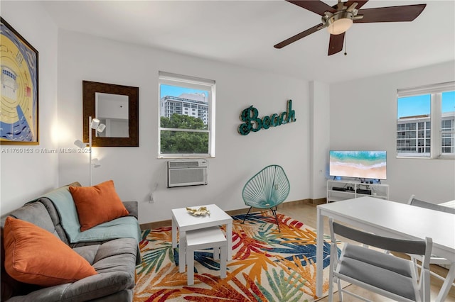 tiled living area featuring a ceiling fan, baseboards, and a wall mounted AC